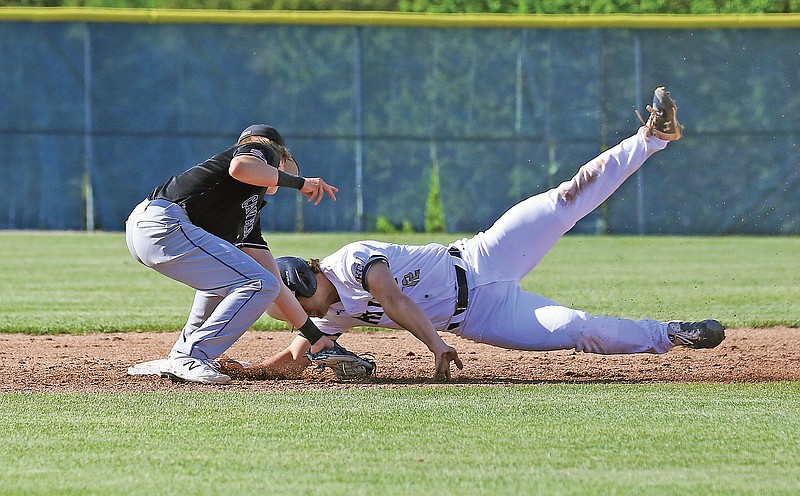 Helias' Jacob Watson attempts to avoid a tag by Capital City second baseman Cooper Rowden during Wednesday's game at the American Legion Post 5 Sports Complex.