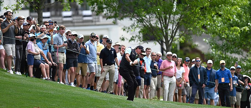 Phil Mickelson hits a shot from a hill near the 15th green during the second round of the Wells Fargo Championship golf tournament at Quail Hollow Club in Charlotte, N.C., Friday, May 7, 2021.  (Jeff Siner/The Charlotte Observer via AP)