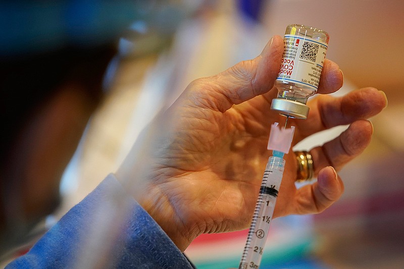 In this Dec. 29, 2020, file photo, Pat Moore, with the Chester County, Pa., Health Department, fills a syringe with Moderna COVID-19 vaccine before administering it to emergency medical workers and health care personnel at the Chester County Government Services Center in West Chester, Pa. The Biden administration's call to lift patent protections on COVID-19 vaccines to help poor parts of the world get more doses has drawn praise from some countries and health advocates. But it has run into resistance from the pharmaceutical industry and others, who say that it won't help curb the outbreak any time soon and will hurt future innovation. (AP Photo/Matt Slocum, File)