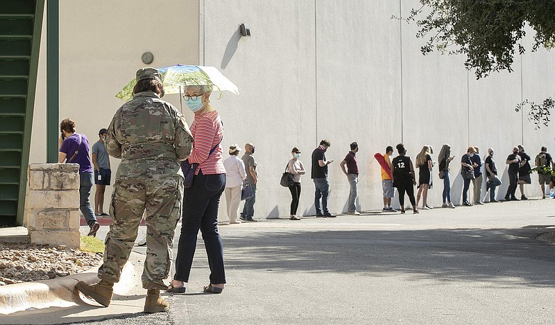 Elsa Demedo, left, and Jeanette Breedlove wait in a long line at an early voting location at Ben Hur Shrine Temple in Austin, Texas. (Jay Janner/Austin American-Statesman/TNS)