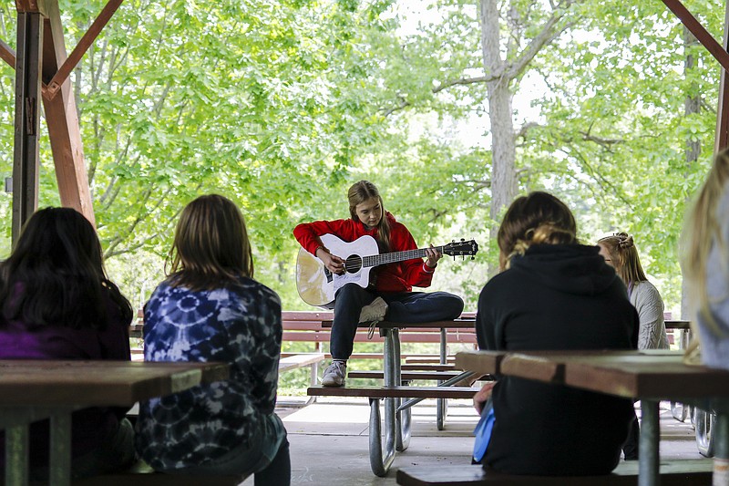 Liv Paggiarino/News Tribune photo: Z-Club member Sarah Case, center, plays a song by The Beatles while talking to girls about music and poetry during the Zonta Club’s Girl Empowerment Day on Saturday, May 8, 2021, at Memorial Park. Middle school-aged girls spent the day celebrating their creativity, strength, intelligence and so much more with group activities like poetry and music, self defense classes and financial skills learning, with presentations by women in various powerful positions, including Mayor Carrie Tergin and members of the Cole County Sheriff’s Department and Cole County EMTs.