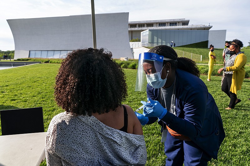 FILE - In this May 6, 2021, file photo, Kendria Brown, a nurse with DC health, vaccinates a woman with the Johnson & Johnson COVID-19 vaccine at The REACH at the Kennedy Center in Washington. From South Carolina to Washington, states are requesting the Biden administration send them only a fraction of what's been allocated to them. The turned-down vaccines amount to hundreds of thousands of doses this week alone, providing a stark illustration of the problem of vaccine hesitancy in the U.S. (AP Photo/Jacquelyn Martin, File)