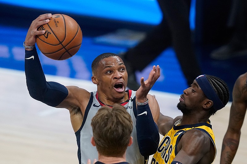 Washington Wizards' Russell Westbrook goes to the basket against Indiana Pacers' Caris LeVert (22) during the first half of an NBA basketball game Saturday, May 8, 2021, in Indianapolis. (AP Photo/Darron Cummings)