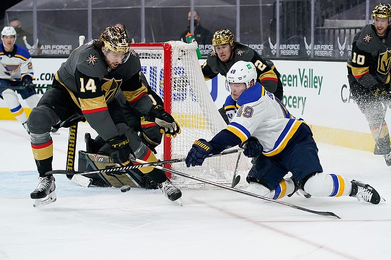 St. Louis Blues center Ivan Barbashev (49) attempts a wrap around shot against Vegas Golden Knights defenseman Nicolas Hague (14) during the third period of an NHL hockey game Friday, May 7, 2021, in Las Vegas. (AP Photo/John Locher)