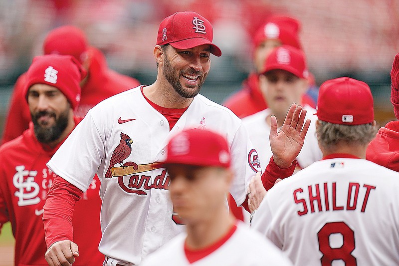 Cardinals starting pitcher Adam Wainwright celebrates with teammates following Sunday afternoon's 2-0 victory against the Rockies at Busch Stadium.