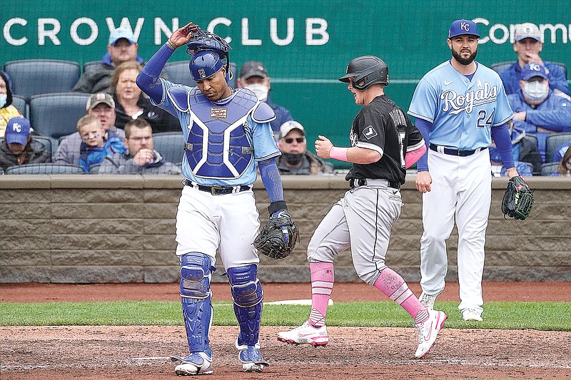 Andrew Vaughn of the White Sox crosses home plate between Royals catcher Salvador Perez and pitcher Jakob Junis to score during the sixth inning of Sunday afternoon's game at Kauffman Stadium.