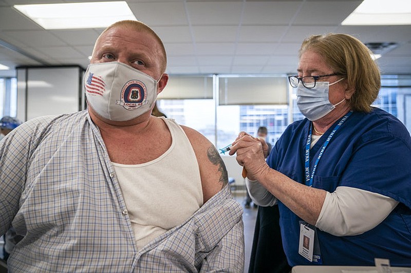 Christine Runyon administered the Moderna COVID-19 vaccine to Michael Christy at United Labor Center in Minneapolis recently. (LEILA NAVIDI/Minneapolis Star Tribune/TNS)