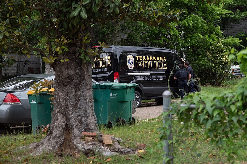 Texarkana, Texas, police officers stand outside their crime scene unit van May 4 in the 700 block of West 26th Street. Police arrested William Ashcraft, 66, and Mildred Ann Malapelli, 65, on sexual assault and other charges after a 22-year-old woman who lived in their home told them she was kept and abused against her will.