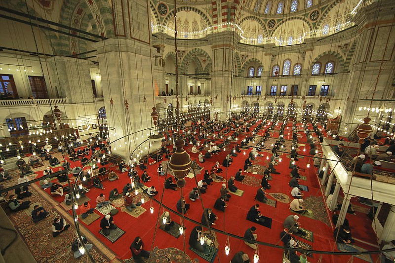 Muslims offer prayers during the first day of Eid al-Fitr, which marks the end of the holy month of Ramadan at Fatih Mosque in Istanbul, Thursday, May 13, 2021. Hundreds of Muslims attended dawn Eid al-Fitr prayers Thursday marking the end of the month of prayer and fasting for Muslims around the world, a usually joyous three-day celebration that has been significantly toned down as coronavirus cases soar. (AP Photo/Emrah Gurel)