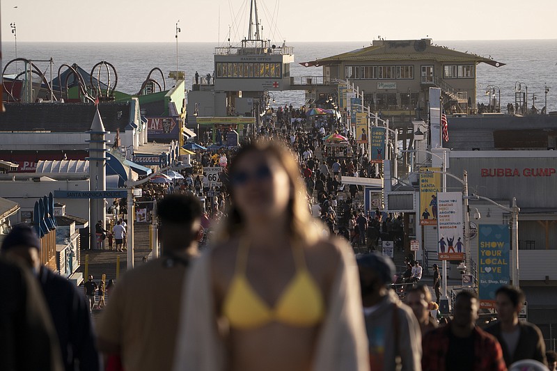 FILE - In this April 7, 2021, file photo, people crowd the Santa Monica Pier in Santa Monica, Calif. Teams of experts are projecting COVID-19's toll on the U.S. will fall sharply by the end of July, according to research released by the government Wednesday, May 5. (AP Photo/Jae C. Hong, File)