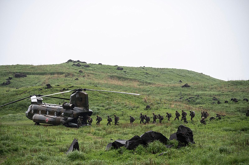 French army soldiers walk into a Chinook helicopter during a joint military drill between Japan Self-Defense Force, French army and U.S. Marines, at the Kirishima exercise area in Ebino, Miyazaki prefecture, southern Japan Saturday, May 15, 2021. (Charly Triballeau/Pool Photo via AP)