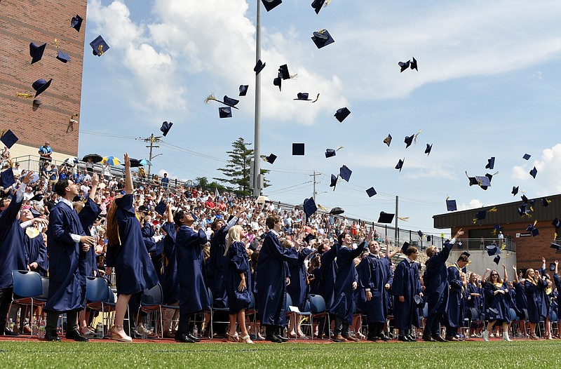 (India Garrish/News Tribune) Helias Catholic High School students throw their caps in the air after graduating Sunday during their ceremony. Although rain was expected, sunny skies and a high of 87 shone down on the graduates. 