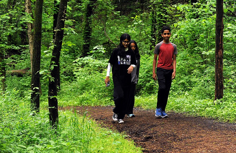 Despite light rainfall coming down, Rahi Patel (right), Anokhi Patel (left) and Rani Patel, all of Jefferson City, were out enjoying a walk along the trails of the Runge Nature Center with other members of their family. Shaun Zimmerman / News Tribune photo