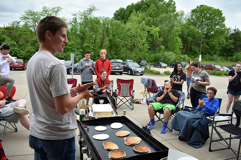 Calvary High School seniors, who are finished with their classes, stayed up all Tuesday night at the school to surprise the faculty and students with a pancake breakfast Wednesday morning. At left, Grant Going, who planned the event, takes a break from cooking pancakes to join in the applause after freshman Jaxson Jobe (not pictured) gave an impromptu speech about how the seniors made his freshman year his best year of school yet.