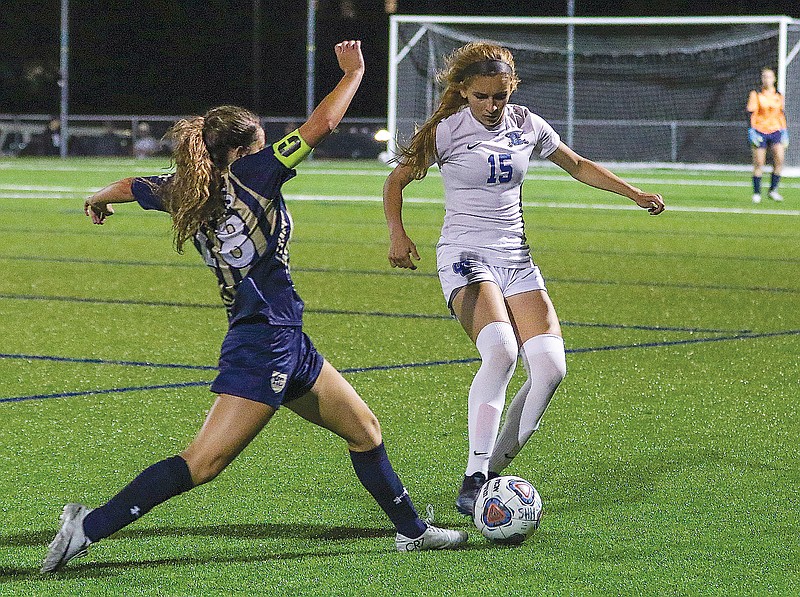 Brooklynn Greene of Capital City kicks the ball away from Caroline McCurren of Helias during Tuesday night's Class 4 District 9 semifinal game at the Crusader Athletic Complex