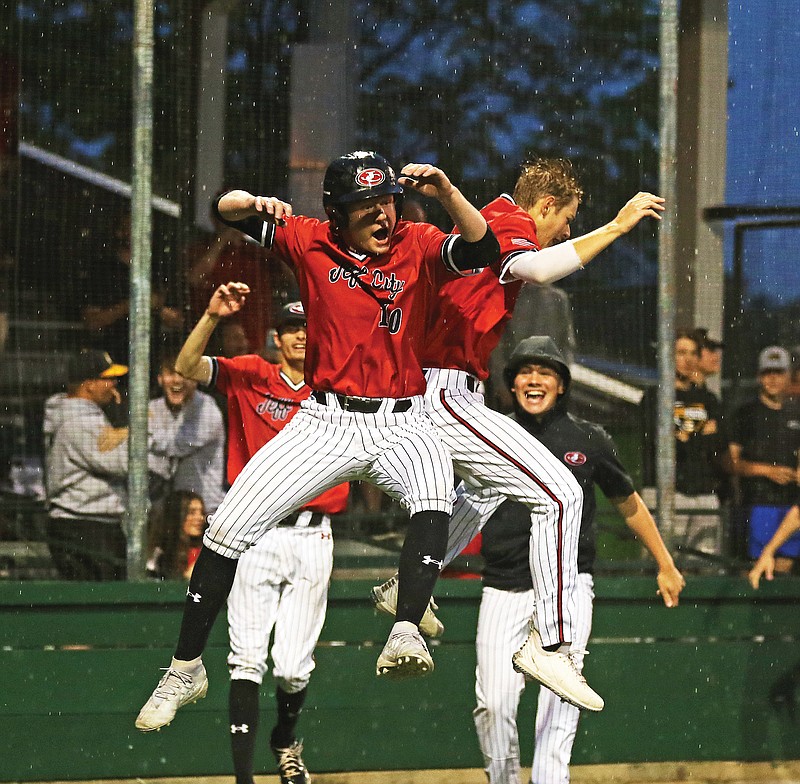 Jefferson City teammates Will Berendzen (10) and Eli Moreland celebrate after Berendzen scored the game-winning run Thursday night in the Class 6 District 5 Tournament championship game at Liberty Park Stadium in Sedalia.