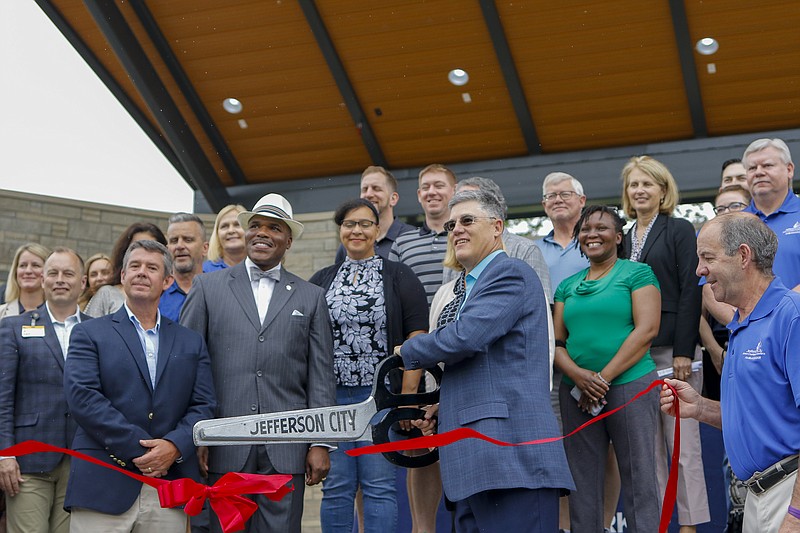 Liv Paggiarino/News Tribune

JC Parks Commission President Chris Lueckel, center, officially cuts the ribbon for the Capital Region MU Health Care Amphitheater on Friday at Ellis-Porter Riverside Park. 
