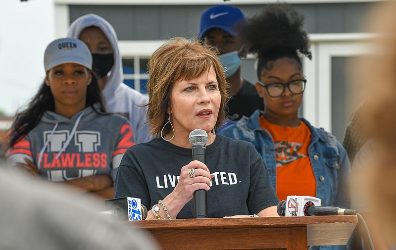 With members of families displaced by the May 2019 tornado standing behind her, Ann Bax, president of the United Way of Central Missouri, expresses gratitude to representatives of numerous non-profit agencies on hand for Wednesday's and to anyone who showed up to help after the May 22, 2019 tornado. They were in front of one of the four houses built by River City Habitat for Humanity following the torndo.