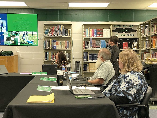 From left, North Callaway R-1 Board of Education members Amy Reinhard, Tim Safranski and Ann Schmidt watch a slide presentation during Thursday night's meeting in the high school media center in Kingdom City. Superintendent Nicky Kemp looks on in the background.