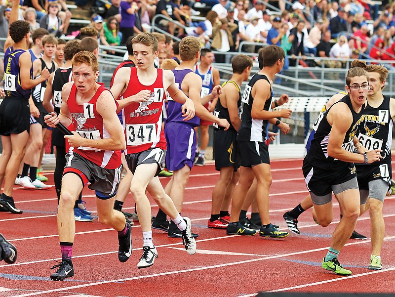 Calvary Lutheran's Cole Going begins a leg of the 4x800-meter relay after taking a handoff from Jaxson Jobe on Saturday in the Class 1 state track and field championships at Adkins Stadium.