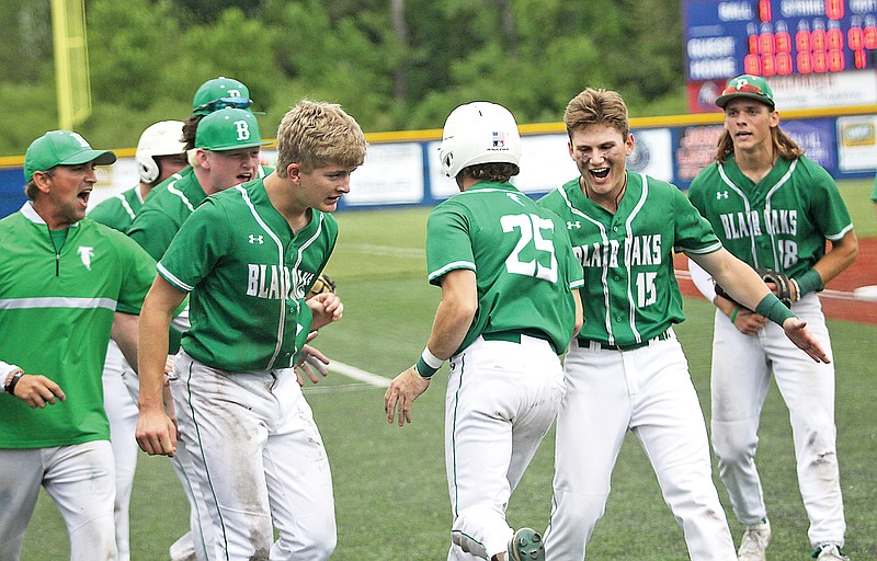 Blair Oaks players congratulate Levi Haney (25) after he scores on a sacrifice fly during the eighth inning of last Thursday's Class 4 District 8 Tournament championship game against Fatima at California.