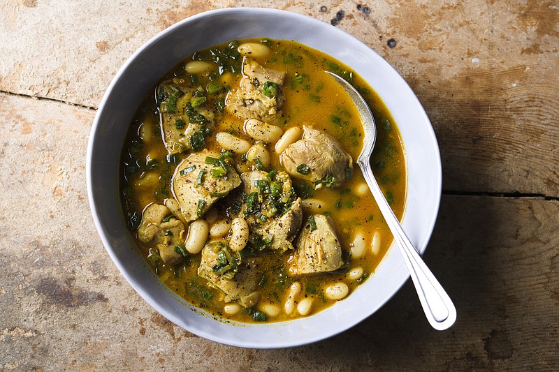 This image released by Milk Street shows a recipe for cardamom lime chicken with white beans. (Milk Street via AP)