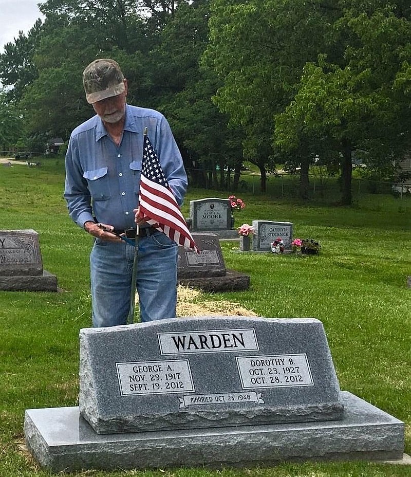 <p>Submitted</p><p>Columnist Dorothy Kleindienst’s husband, David, places an American flag next to her father’s gravestone.</p>