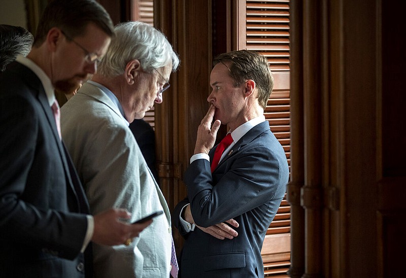 House Speaker Dade Phelan, R-Beaumont, right, talks to Republican members of the Texas House before the start of the debate of Senate Bill 7, known as the Election Integrity Protection Act, at the Capitol on Sunday, May 30, 2021, in Austin, Texas. (Jay Janner/Austin American-Statesman via AP)