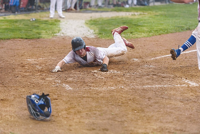 Linn's Andy Hueste slides into home safely on a wild pitch in the top of the fifth inning of last Tuesday's Class 3 sectional game against Forsyth at Linn.