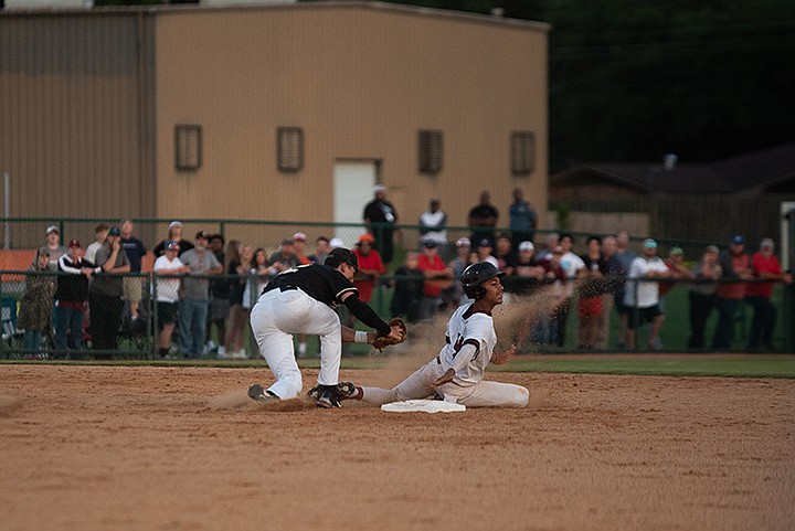 Liberty-Eylau player Zander Hall slides into second base as a Pleasant Grove player follows him with the ball during the first game of the Region II-4A championship series Wednesday night at Texas High in Texarkana. Staff photo by Kelsi Brinkmeyer