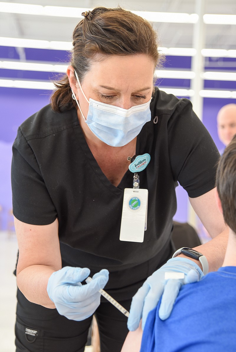 JCMG registered nurse Melinda Sperandio administers a dose of the COVID-19 vaccine Thursday at the Cole County Health Department's vaccination clinic inside Capital Mall. 