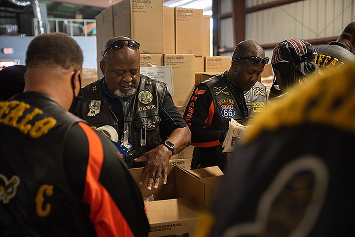 Stephan "Hawk" Hall packs boxes Friday, June 5, 2021, for Harvest Regional Food Bank with the Buffalo Soldiers for the community service portion of the Central Fontier Meeting. The meeting is being held in Texarkana this weekend for the Central Frontier, or region, consisting of seven states. The Buffalo Soldiers are a group spread over the whole nation, all taking part to educate the public on the history of the Buffalo Soldiers and doing work to give back to their communities. Staff photo by Kelsi Brinkmeyer