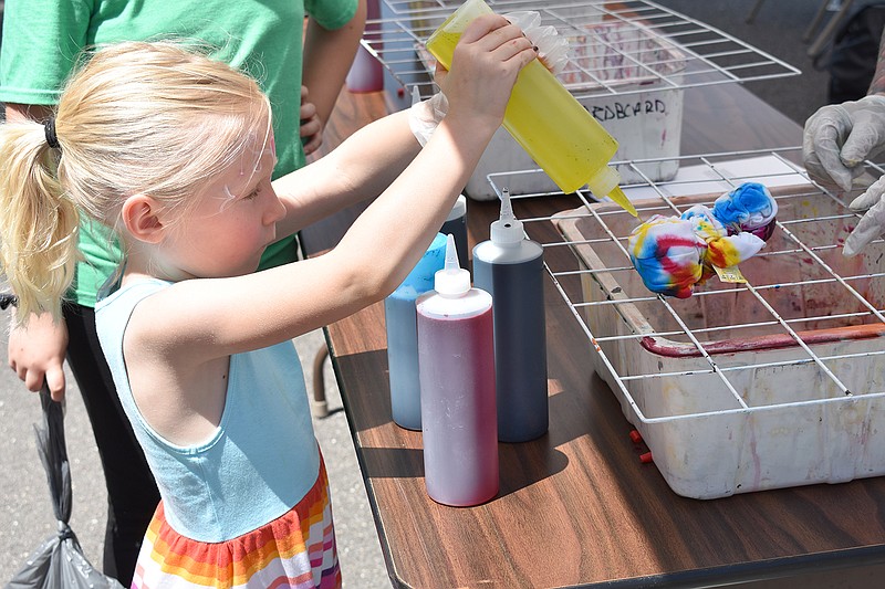 News Tribune fileAudrey King, of Lee’s Summit, makes at tie-dye T-shirt in 2019 at the second PorchFest JCMO event. After being held virtually in 2020, the event returns Sunday to Capitol Avenue.