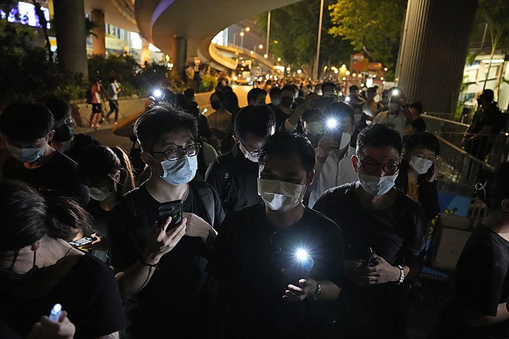 People light LED candles to mark the anniversary of the military crackdown on a pro-democracy student movement in Beijing, outside Victoria Park in Hong Kong, Friday, June 4, 2021. A member of the committee that organizes Hong Kong's annual candlelight vigil for the victims of the Tiananmen Square crackdown was arrested early Friday on the 32nd anniversary. (AP Photo/Kin Cheung)