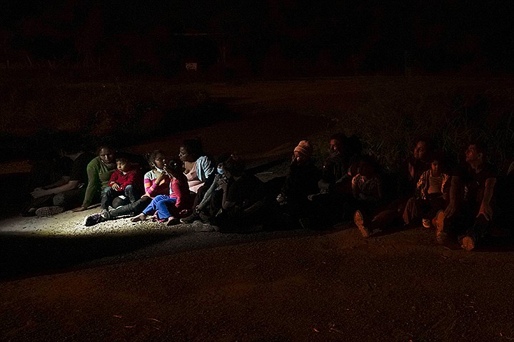 Migrants mainly from Honduras and Nicaragua sit in line after turning themselves in upon crossing the U.S.-Mexico border Monday, May 17, 2021, in La Joya, Texas. The Biden administration has quietly tasked six humanitarian groups with recommending which migrants should be allowed to stay in the U.S. instead of being rapidly expelled from the country under federal pandemic-related powers that prevent many from seeking asylum. (AP Photo/Gregory Bull, file)