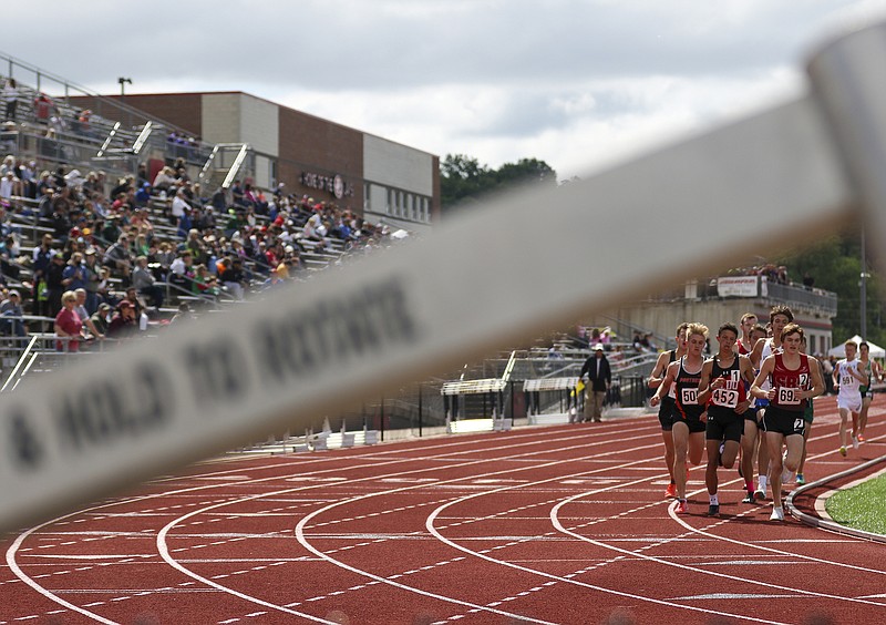 Participants in the boys 3,200-meter run round the corner of Licklider Track at the Class 3 state track and field championships last month at Adkins Stadium.
