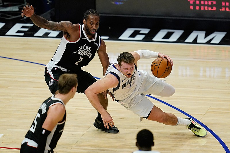 Los Angeles Clippers forward Kawhi Leonard (2) defends against Dallas Mavericks guard Luka Doncic (77) during the fourth quarter of Game 7 of an NBA basketball first-round playoff series Sunday, June 6, 2021, in Los Angeles, Calif. (AP Photo/Ashley Landis)