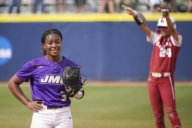 James Madison starting pitcher Odicci Alexander stands in the pitching circle as Oklahoma's Jayda Coleman celebrates at second base behind her after hitting a double in the fifth inning of Monday's Women's College World Series game in Oklahoma City.