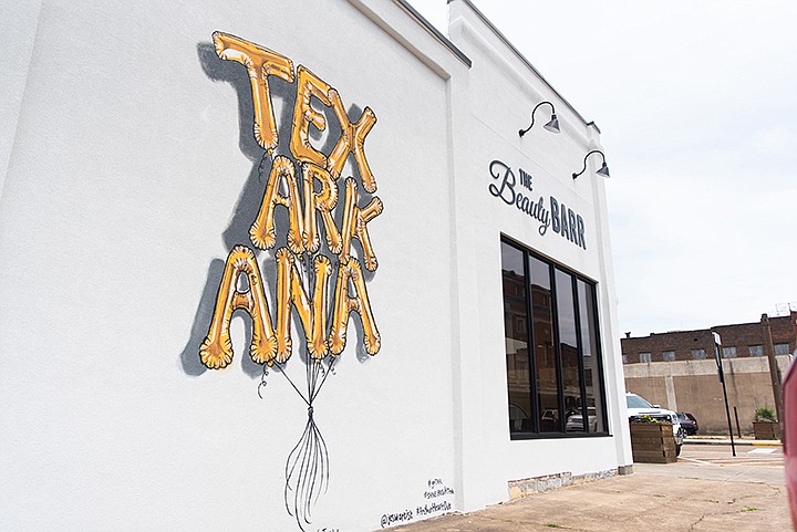 A new mural was painted over the weekend by artist Jes Weiner on the corner of Main Street and Third Street in downtown Texarkana. The mural is interactive, allowing passerby to walk up and pretend that they are holding a set of gold balloons that read "Texarkana."Staff photo by Kelsi Brinkmeyer
