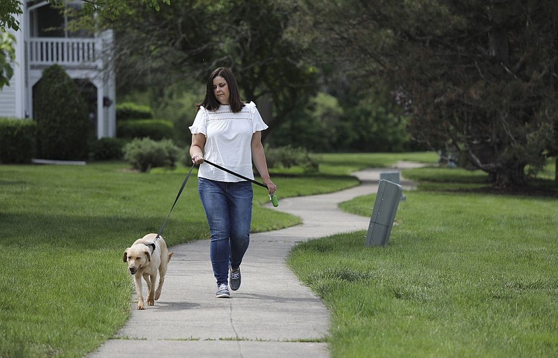 Beth Wawrzaszek, of Naperville, Illinois, takes her dog Summer out for a short walk outside her apartment on May 21, 2021. Wawrzaszek has hired a dog walker to help while she is at work. (Abel Uribe/Chicago Tribune/TNS)