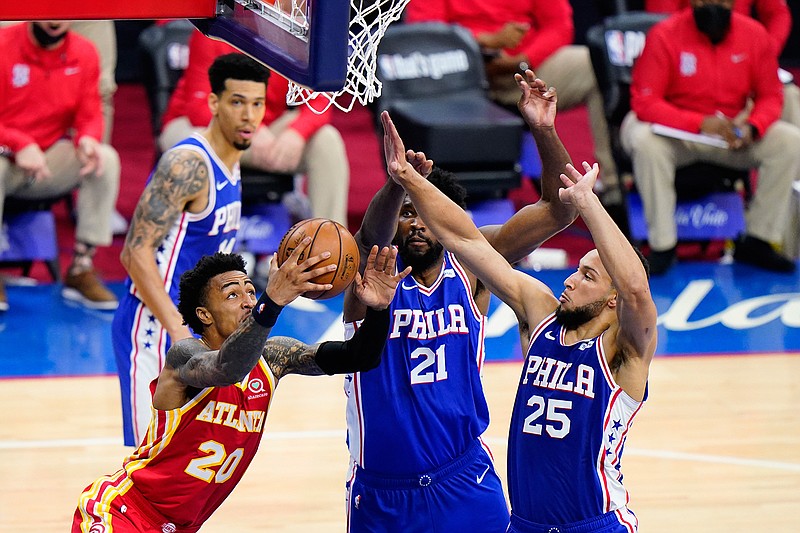 Atlanta Hawks' John Collins (20) goes up for a shot against Philadelphia 76ers' Joel Embiid (21) and Ben Simmons during the second half of Game 2 in a second-round NBA basketball playoff series, Tuesday, June 8, 2021, in Philadelphia. (AP Photo/Matt Slocum)