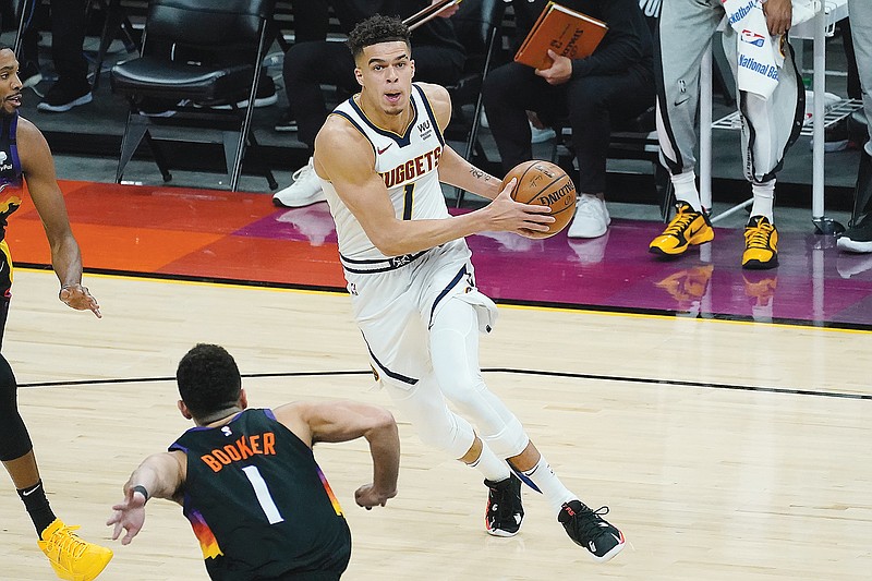 Michael Porter Jr. of the Nuggets drives against the defense of Devin Booker of the Suns during Monday night's NBA playoff game in Phoenix.