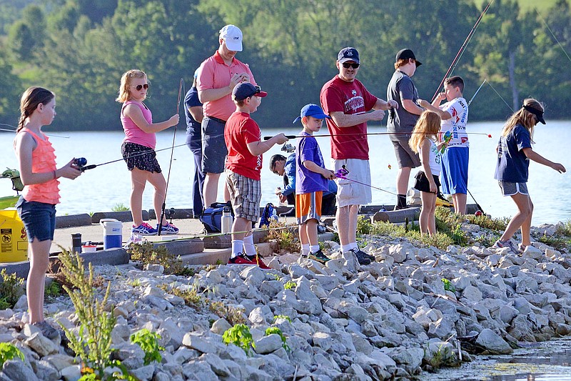 News Tribune fileChildren and parents cast lines off a pier  June 8, 2019, during the Kids Fishing Derby at Binder Lake.