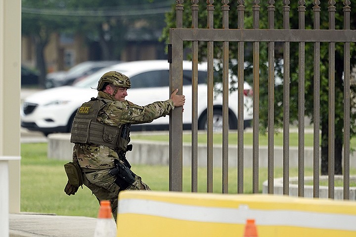 A military policeman closes a gate at JBSA-Lackland Air Force Base, Wednesday, June 9, 2021, in San Antonio. The Air Force was put on lockdown as police and military officials say they searched for two people suspected of shooting into the base from outside. (AP Photo/Eric Gay)
