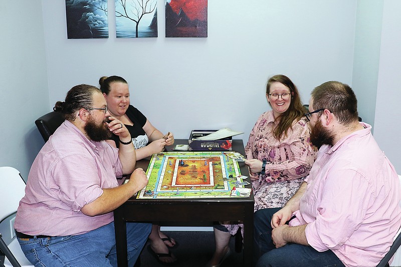 The owners of Mimics JC, John Gaddy (front left), Heather Gaddy (top left), Chelsea Thompson (top right) and Andrew Thompson (bottom right), play the board game Talisman on Wednesday evening, June 9, 2021. Mimics JC, located at 312 Lafayette St., has several rooms designated for certain activites, such as board games, reading, card games and studying. 
