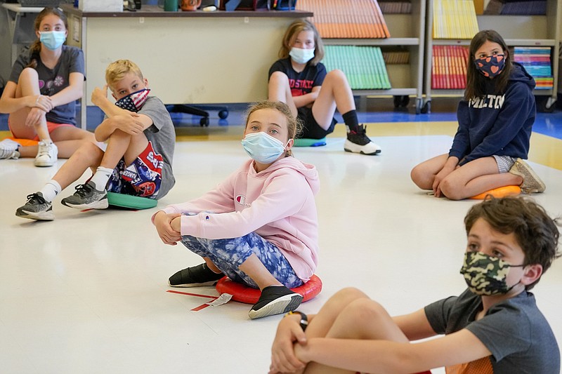 FILE - In this May 18, 2021 file photo, fifth graders wear face masks are seated at proper social distancing spacing during a music class at the Milton Elementary School in Rye, N.Y.  As more children go back to the physical classroom, families are expected to spend robustly on a wide range of items, particularly  trendy clothing for the critical back-to-school season, according to one key spending measure. (AP Photo/Mary Altaffer, File)