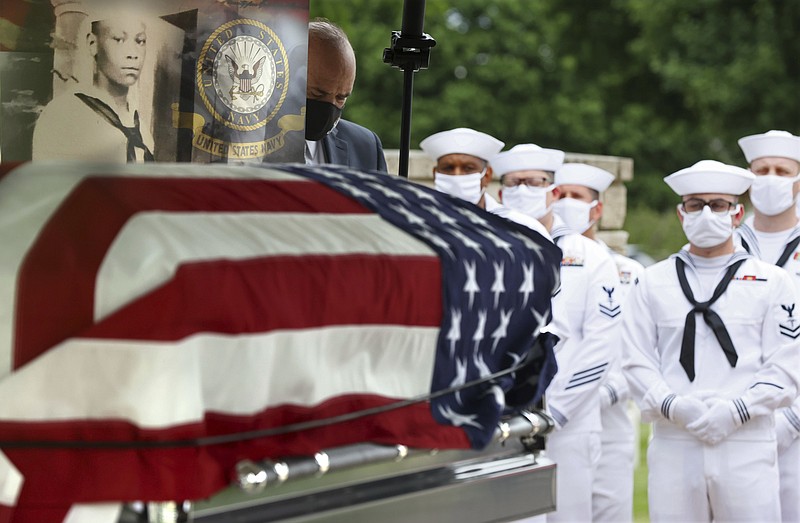 The casket with the remains of Mess Attendant 3rd Class Isaac Parker, 17, is positioned during his funeral ceremony with full military honors at Jefferson Barracks National Cemetery, in St. Louis County, Mo., on Tuesday, June 8, 2021. Parker was laid to rest in St. Louis nearly 80 years after his death on board the USS Oklahoma during the surprise attack at the Pearl Harbor naval base in 1941. Parker's unidentified remains had been buried as an 'unknown' at the National Memorial Cemetery of the Pacific in Honolulu since the 1940s. They were recently identified by DNA, dental and anthropological analysis and returned to his family, now in St. Louis. ( Christian Gooden/St. Louis Post-Dispatch via AP)