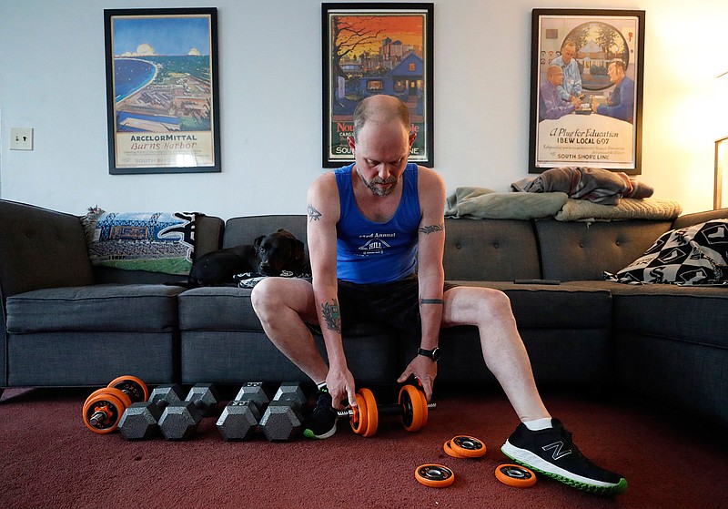 Christian Hainds prepares for a workout session at his home in Hammond, Ind., Monday, June 7, 2021. Health officials have warned since early on in the pandemic that obesity and related conditions such as diabetes were risk factors for severe COVID-19. It wasn't until he was diagnosed as diabetic around the start of the pandemic that he felt the urgency to make changes. Hainds lost about 50 pounds during the pandemic, and at 180 pounds and 5 feet, 11 inches tall is no longer considered obese. (AP Photo/Shafkat Anowar)