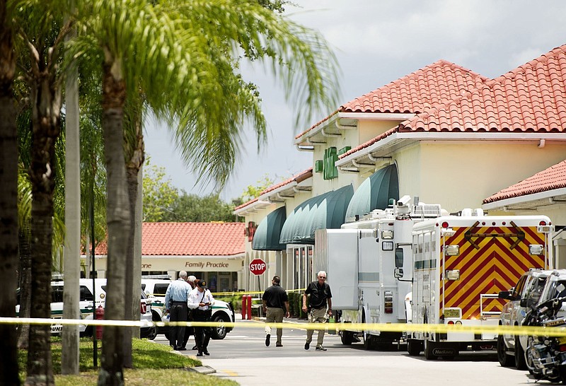 Police gather at the Publix shopping center at the scene of a shooting in Royal Palm Beach, Fla., on Thursday, June 10, 2021.  Authorities say a shooting inside a Florida supermarket has left three people dead, including the shooter.  (Greg Lovett /The Palm Beach Post via AP)