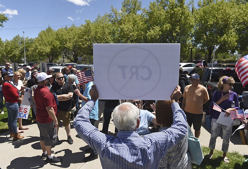 A man holds up a sign against Critical Race Theory during a protest outside a Washoe County School District board meeting on May 25, 2021, in Reno, Nev. Nevada school boards are becoming hotbeds of political polarization where parents are clashing over how to teach students about racism and its role in U.S. history. In Washoe County and Carson City, parents spoke Tuesday, June 8, 2021, against the concept of critical race theory being taught in schools, despite the fact that officials in both districts insist they have no plans to include it in lesson plans. (Andy Barron/Reno Gazette-Journal via AP)